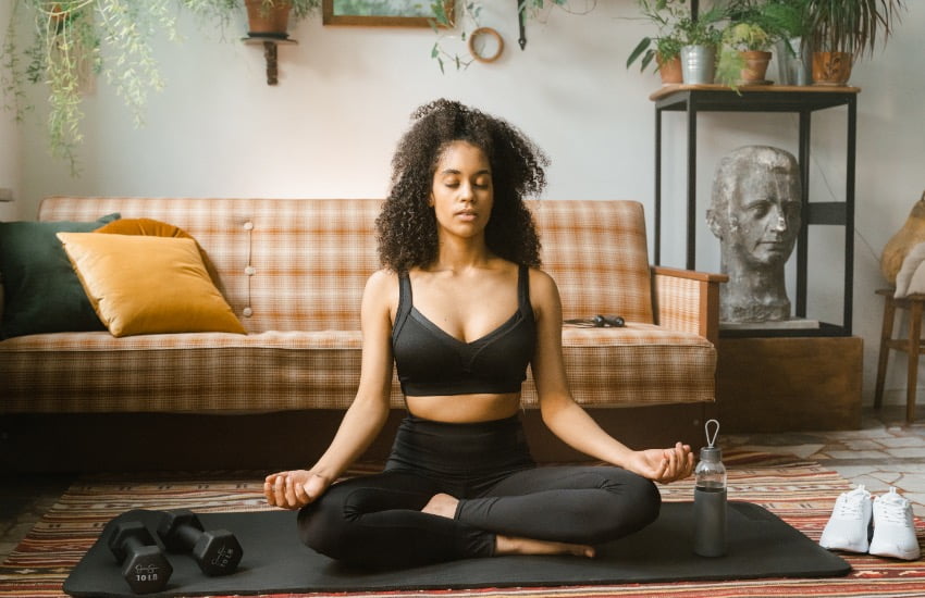 What are the Benefits of Guided Meditation? Turns out A lot! 4 Woman sitting down at home and trying to meditate